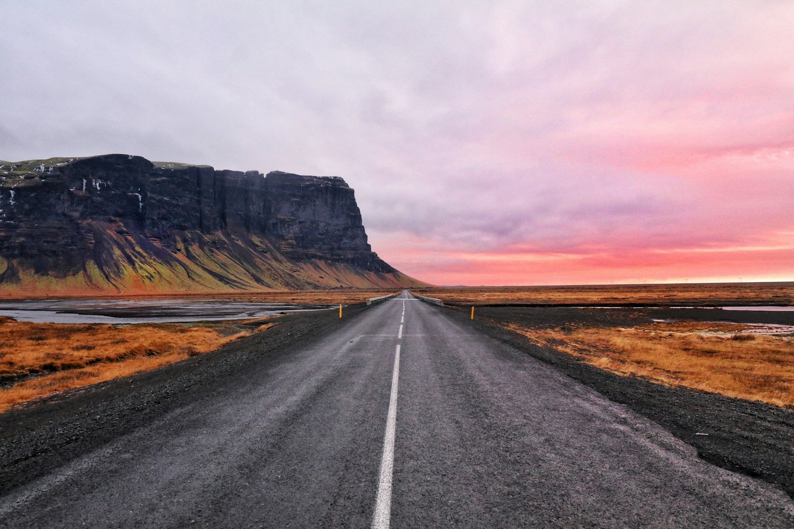 An empty road stretching towards a cliff on the horizon